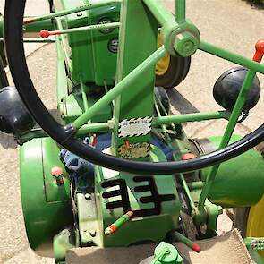 De werkplek van de John Deere B met rechts onder meer de handkoppeling. De rode knop links onder op de plek waar bij normale trekkers de koppeling zit, is de startknop of eigenlijk het startpedaal. De bedoeling is dat je de knop met de voet indrukt.