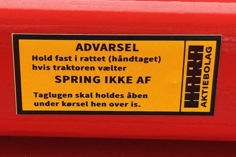 Deze sticker In de cabine van de 814 vertelt de bestuurder wat hij niet moet doen als de trekker kantelt. Dat is er NIET afspringen. Ikke is Zweeds voor niet.