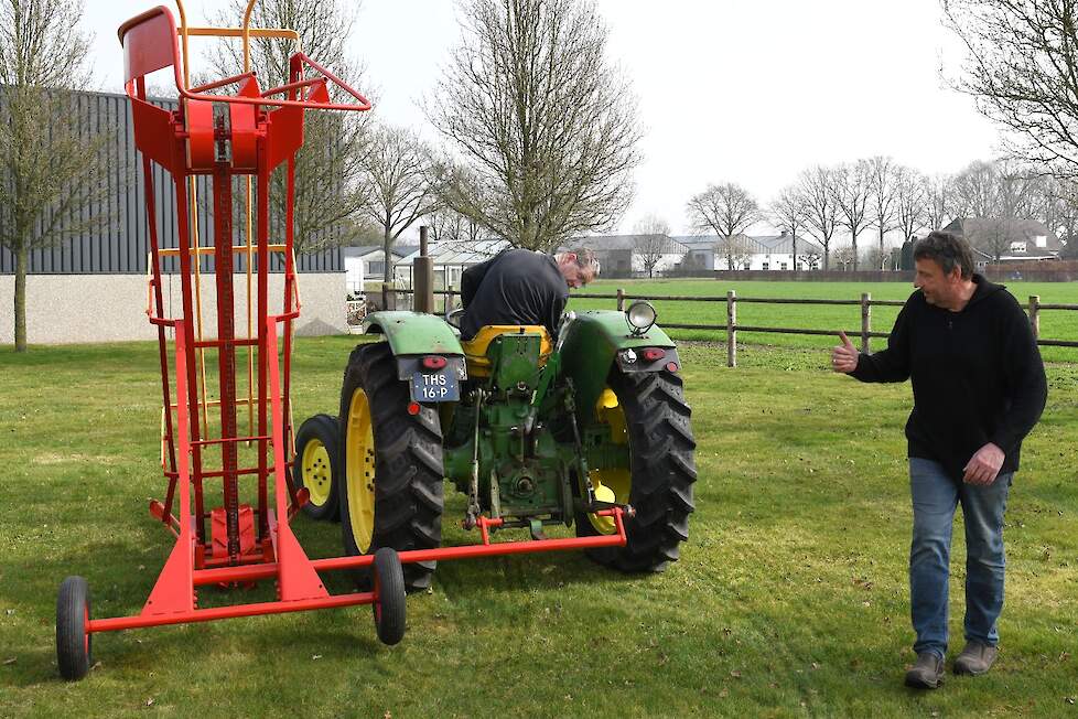 Nog iets hoger heffen gebaart Arold naar Carlo als ze aan het voordoen zijn hoe de pakjeslader werkt.